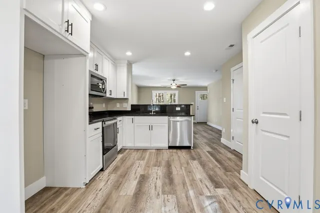 a kitchen with stainless steel appliances a refrigerator sink and cabinets