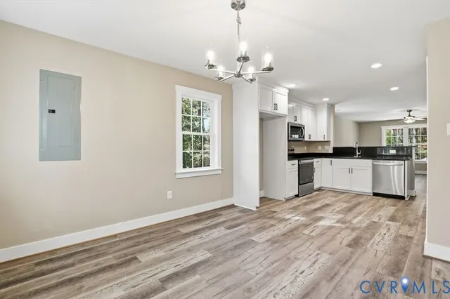 a view of kitchen with granite countertop cabinets and refrigerator