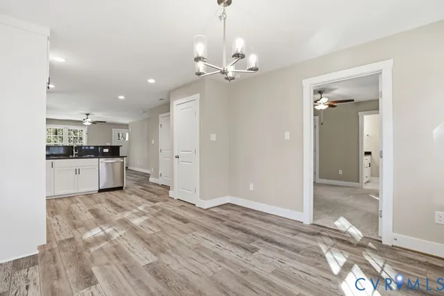 a view of kitchen with granite countertop cabinets and chandelier