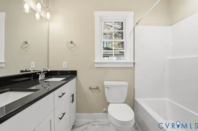 a bathroom with a granite countertop sink a toilet a mirror and shower