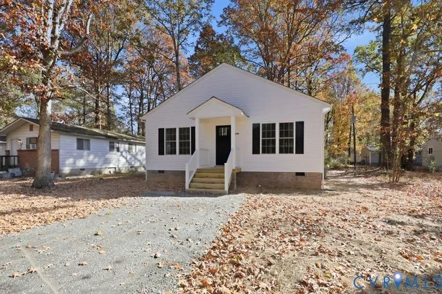 a front view of a house with a yard covered in snow