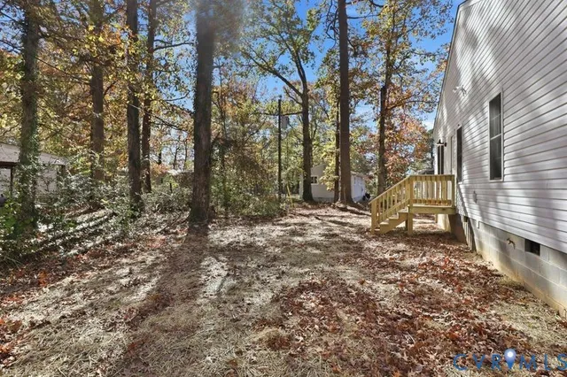 a view of a yard with plants and trees