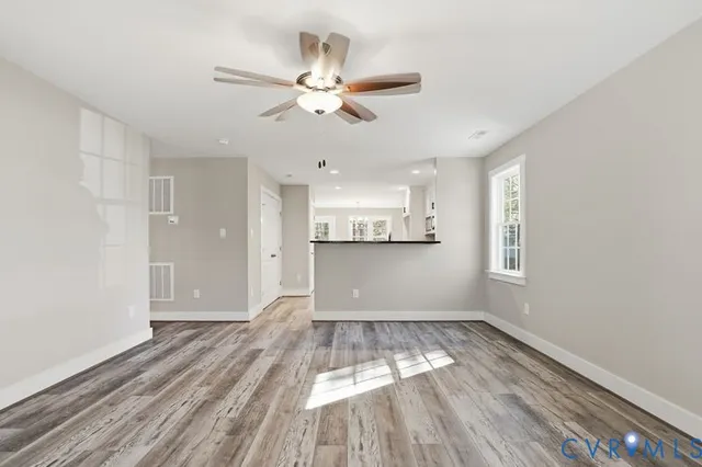 a view of empty room with wooden floor and window