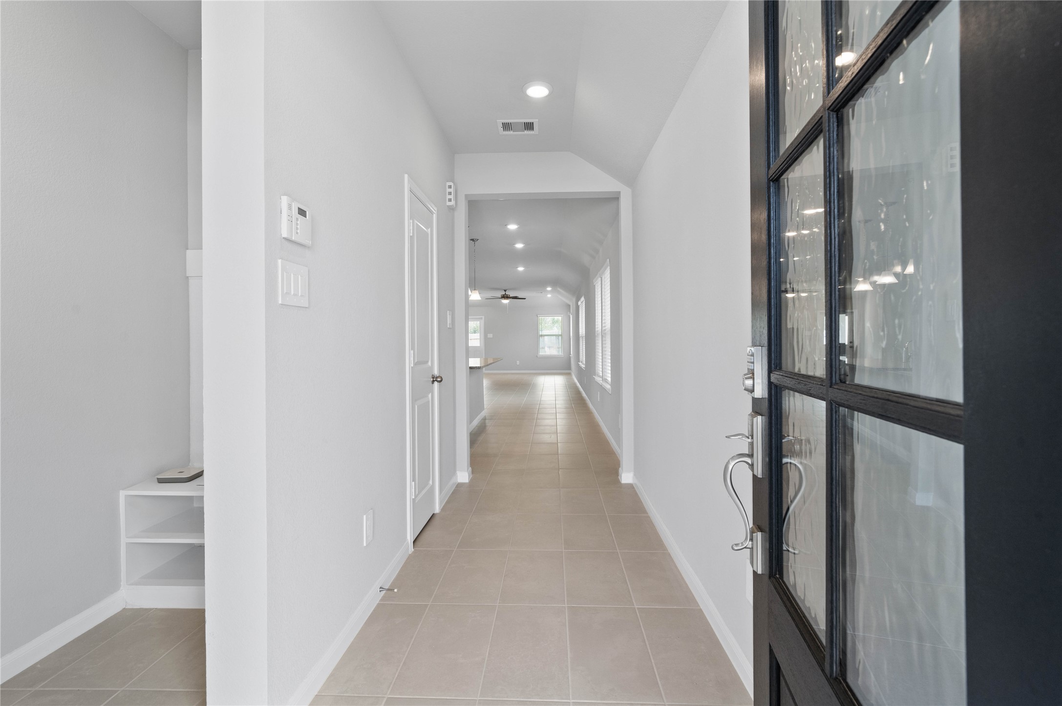 19555 Montgomery Rdg Way Montgomery, TX 77316 - Photo 6 of 38 This entryway features a modern, open-concept design. The long, bright corridor utilizes a neutral color palette, recessed lighting, and floor tiles to lead the eye toward the home's main living area.