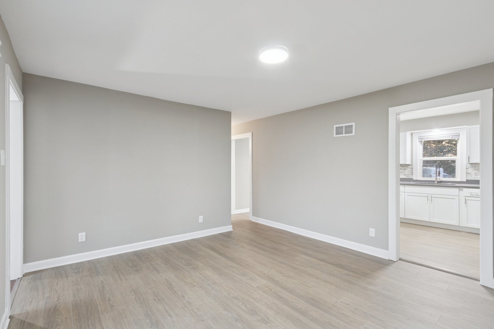 519 South Sycamore Street Genoa, IL 60135 - Photo 5 of 36 a view of an empty room with window and wooden floor