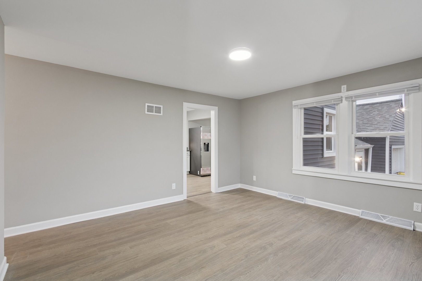 519 South Sycamore Street Genoa, IL 60135 - Photo 6 of 36 a view of an empty room with wooden floor and a window