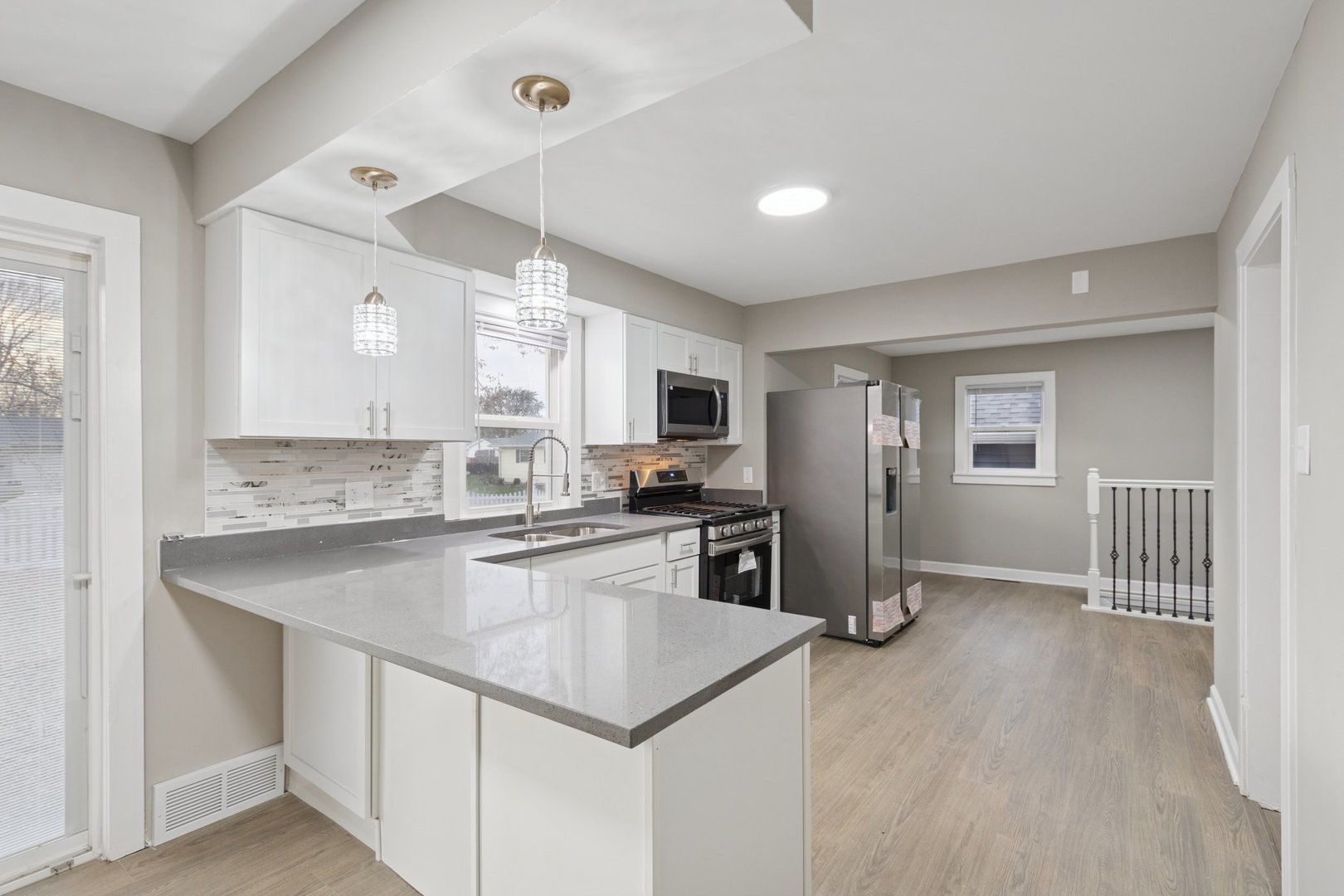 519 South Sycamore Street Genoa, IL 60135 - Photo 8 of 36 a kitchen with stainless steel appliances granite countertop a refrigerator a sink dishwasher a stove and white countertops with wooden floor