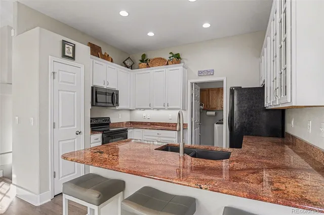 a kitchen with stainless steel appliances granite countertop a refrigerator and a stove top oven