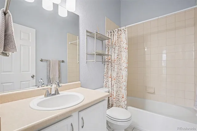 a bathroom with a sink a toilet a mirror a bathtub and shower