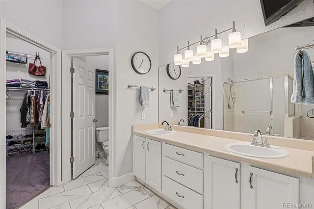 a bathroom with a double vanity sink mirror and toilet