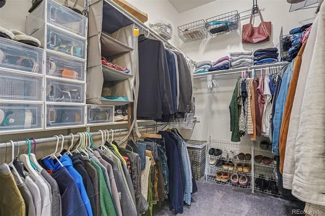 a view of walk in closet with clothes and shoes