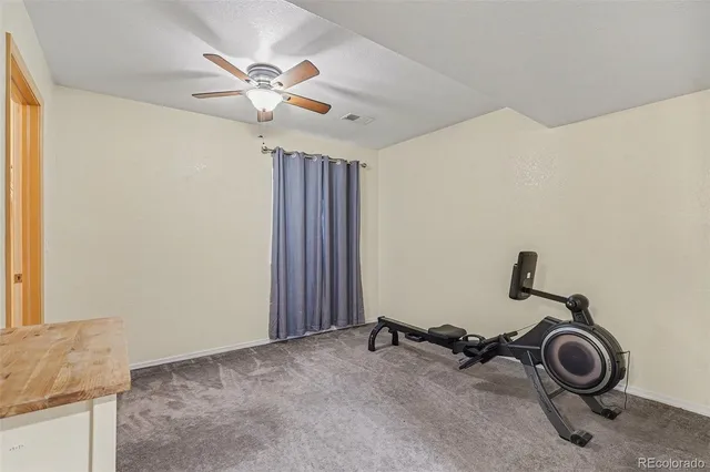 a view of a room with a hanging light and kitchen view