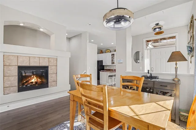 a dining room with wooden floor a chandelier a wooden table and chairs