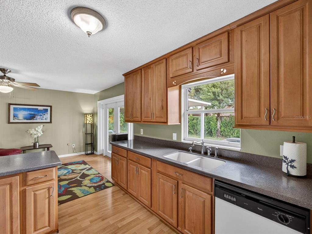 2803 Banchory Road Winter Park, FL 32792 - Photo 6 of 31 a kitchen with stainless steel appliances granite countertop a sink dishwasher stove and cabinets with wooden floor