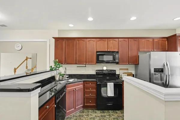 a kitchen with stainless steel appliances granite countertop a stove a sink dishwasher a refrigerator and a microwave