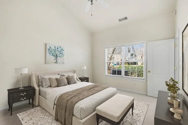 a bedroom with a bed a painting and a window