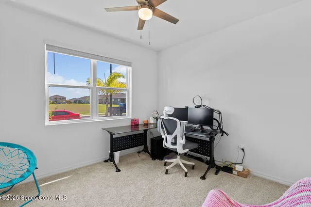 a view of a workspace with furniture and a window