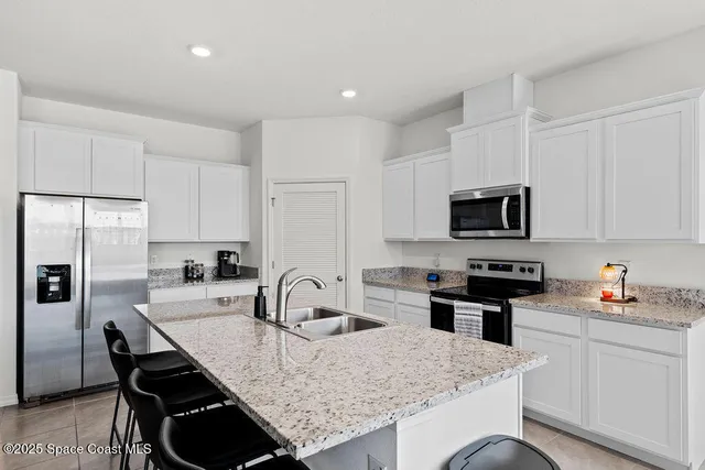 a kitchen with stainless steel appliances granite countertop a sink microwave and cabinets