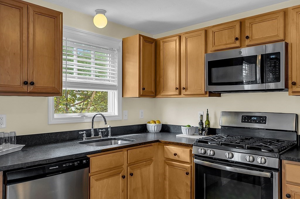 417 Hildreth Street, Unit 3 Lowell, MA 01850 - Photo 4 of 37 a kitchen with stainless steel appliances granite countertop a sink stove and microwave