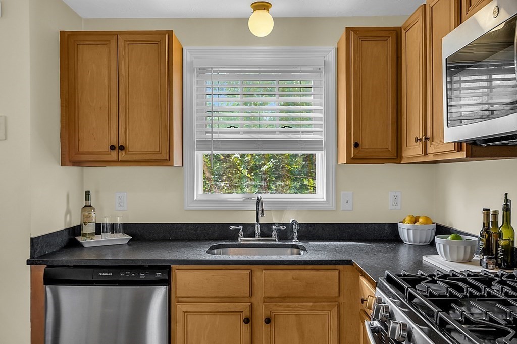 417 Hildreth Street, Unit 3 Lowell, MA 01850 - Photo 5 of 37 a kitchen with stainless steel appliances granite countertop a sink a stove cabinets and a window