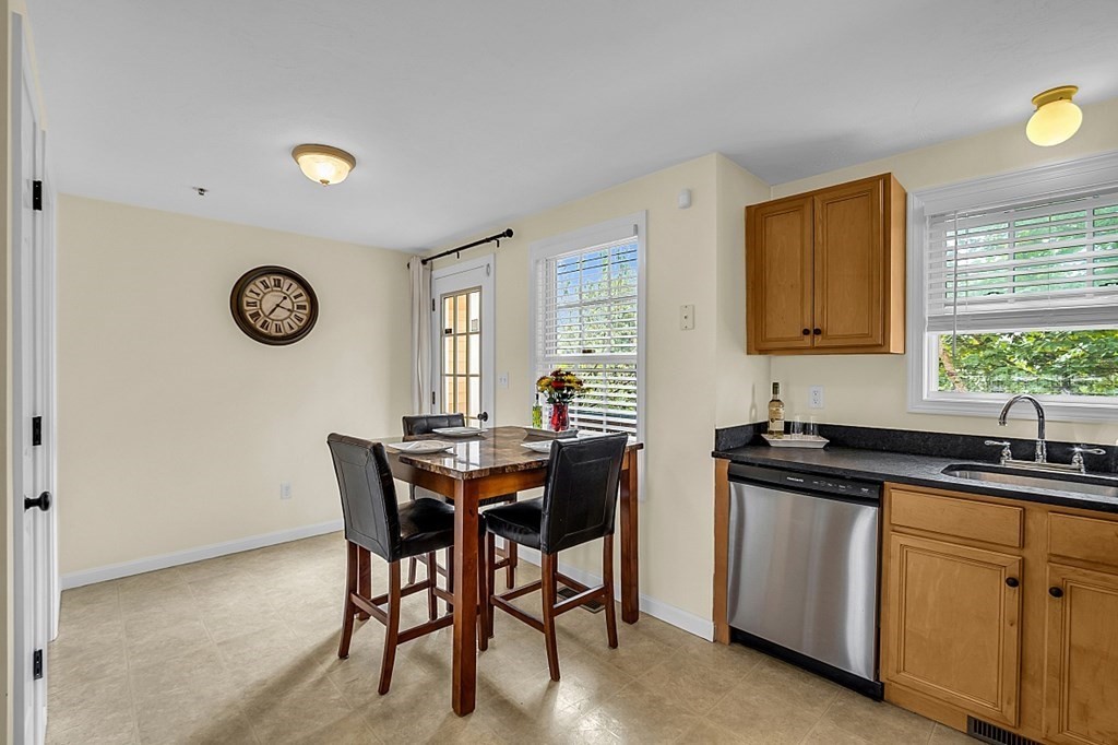 417 Hildreth Street, Unit 3 Lowell, MA 01850 - Photo 6 of 37 a kitchen with a table chairs and a refrigerator