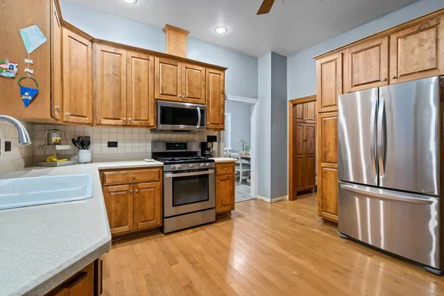 a kitchen with stainless steel appliances a refrigerator and a stove top oven