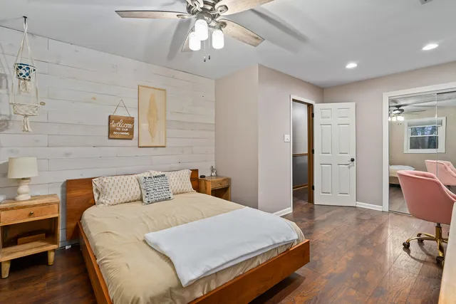 a bedroom with a bed closet and a chandelier