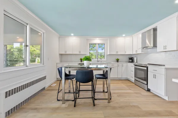 a kitchen with a table chairs sink and cabinets