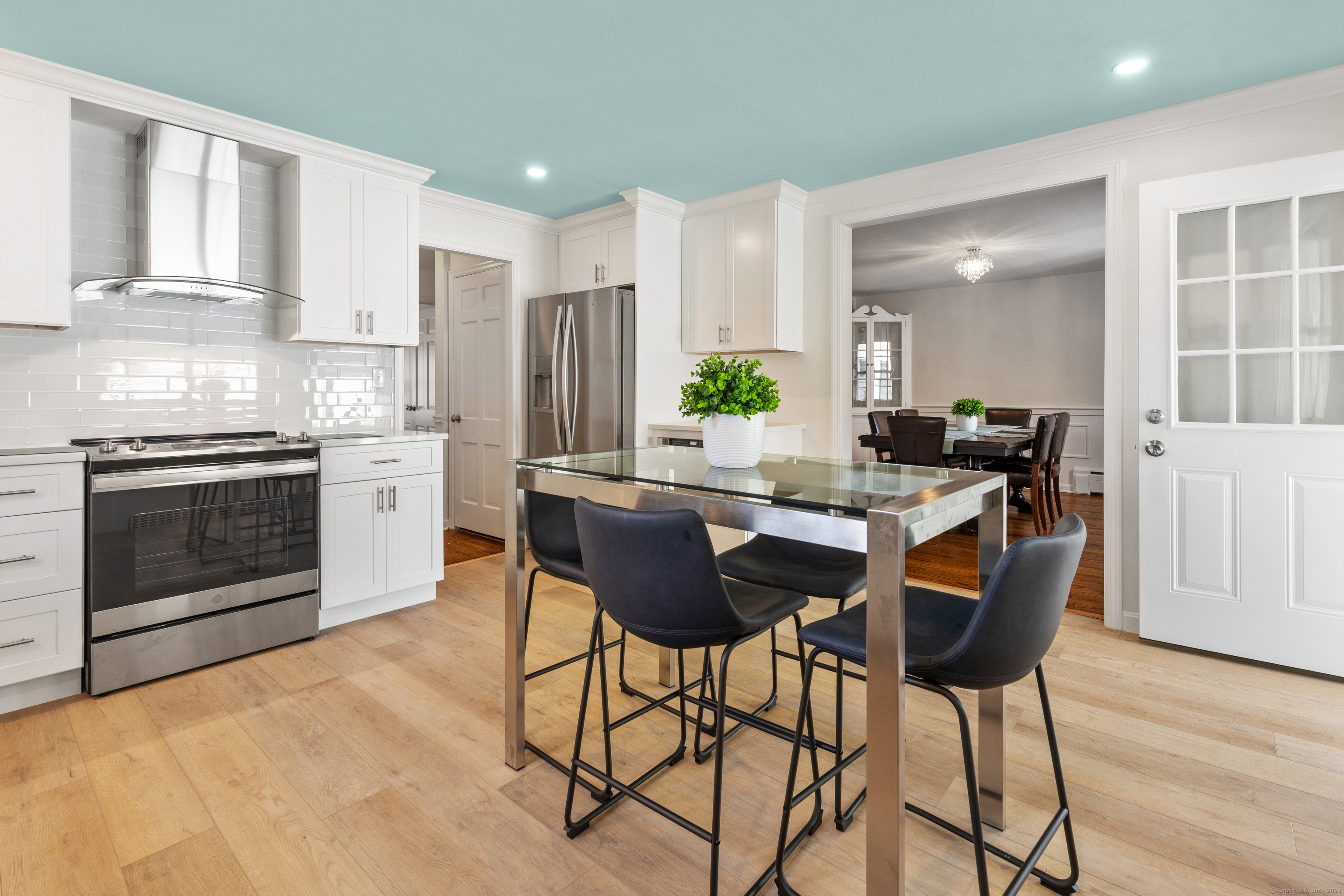 72 Cherry Lane Madison, CT 06443 - Photo 13 of 40 a kitchen with stainless steel appliances granite countertop a stove a refrigerator a sink a dining table and chairs