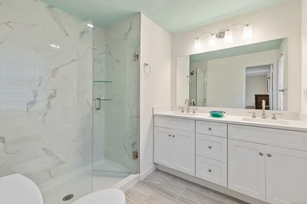 a bathroom with a shower sink and mirror
