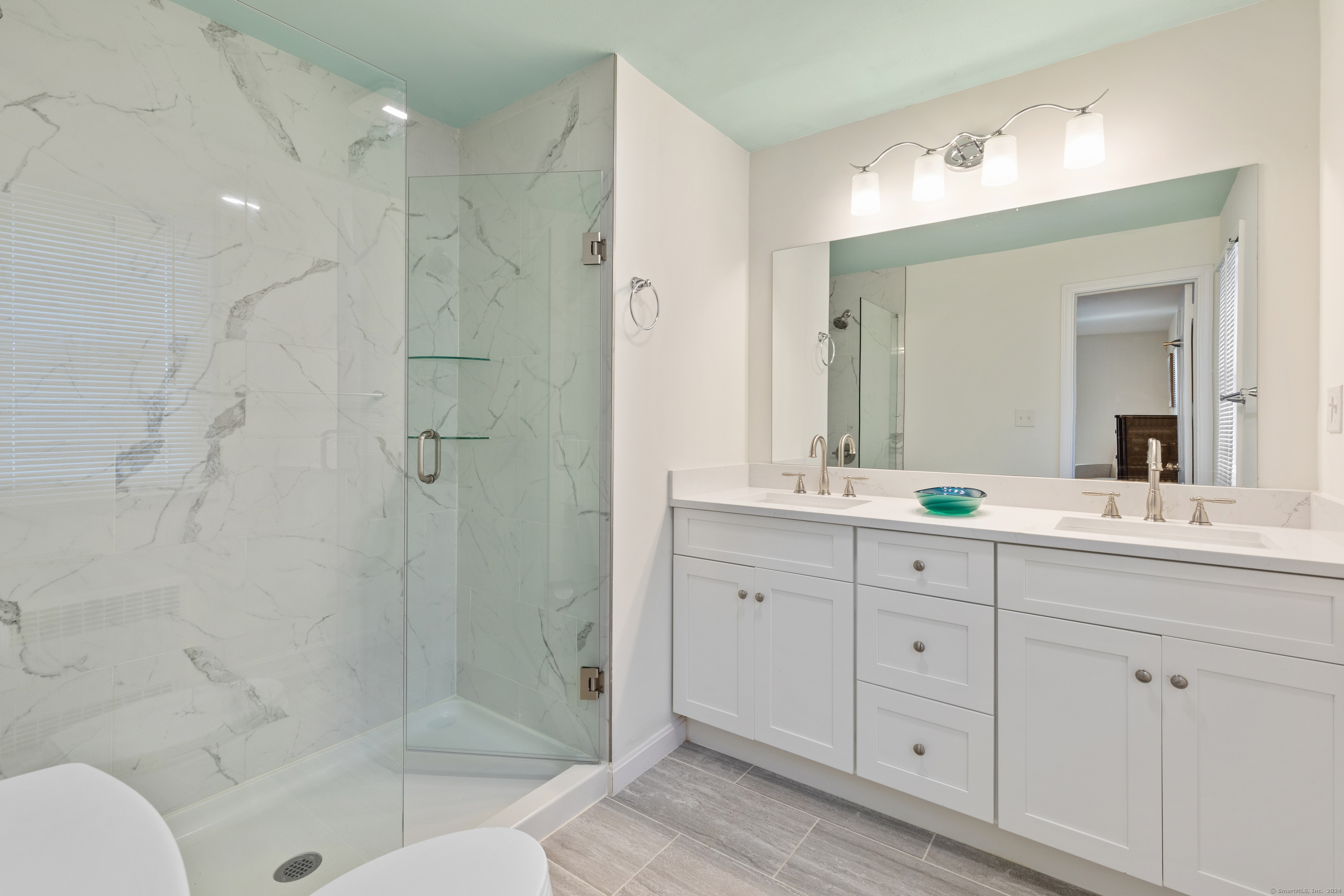 72 Cherry Lane Madison, CT 06443 - Photo 20 of 40 a bathroom with a shower sink and mirror