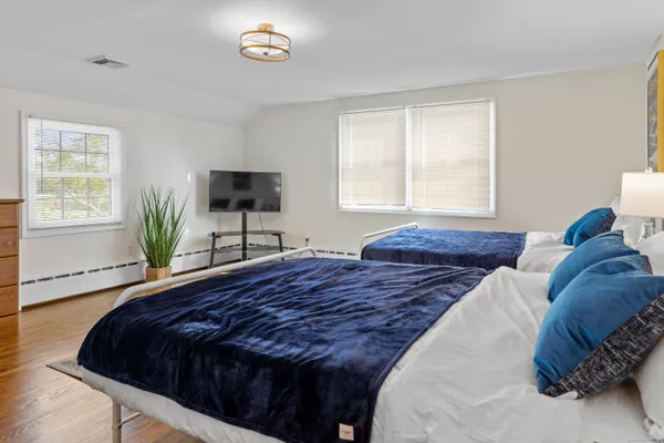 a bedroom with a bed and a flat tv screen on the dresser