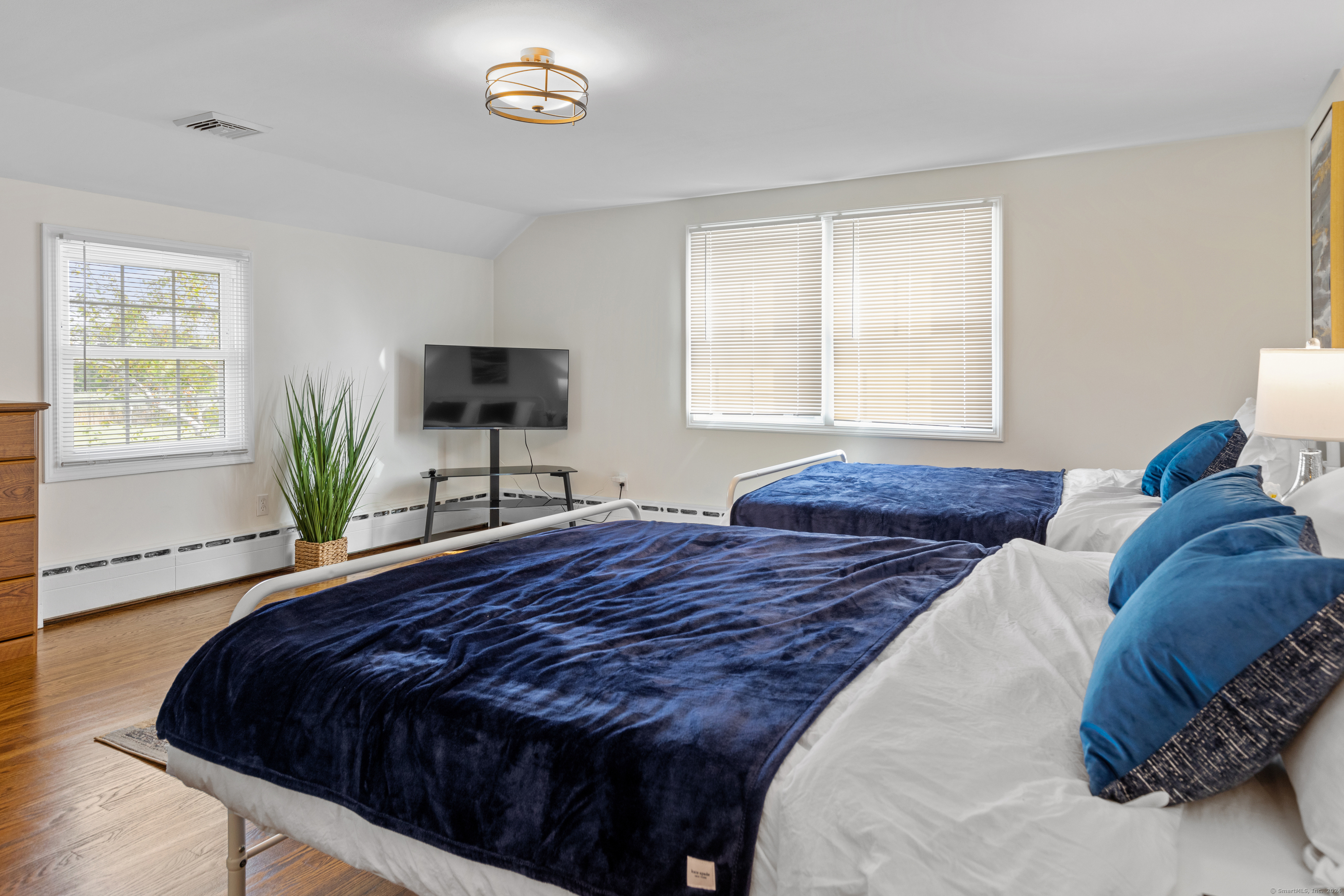 72 Cherry Lane Madison, CT 06443 - Photo 32 of 40 a bedroom with a bed and a flat tv screen on the dresser