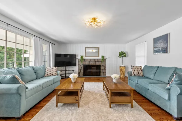 a living room with furniture a flat screen tv and a fireplace