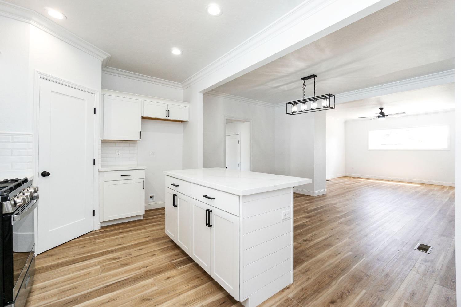 133 South Reed Avenue Reedley, CA 93654 - Photo 13 of 42 a kitchen with cabinets stove and wooden floor
