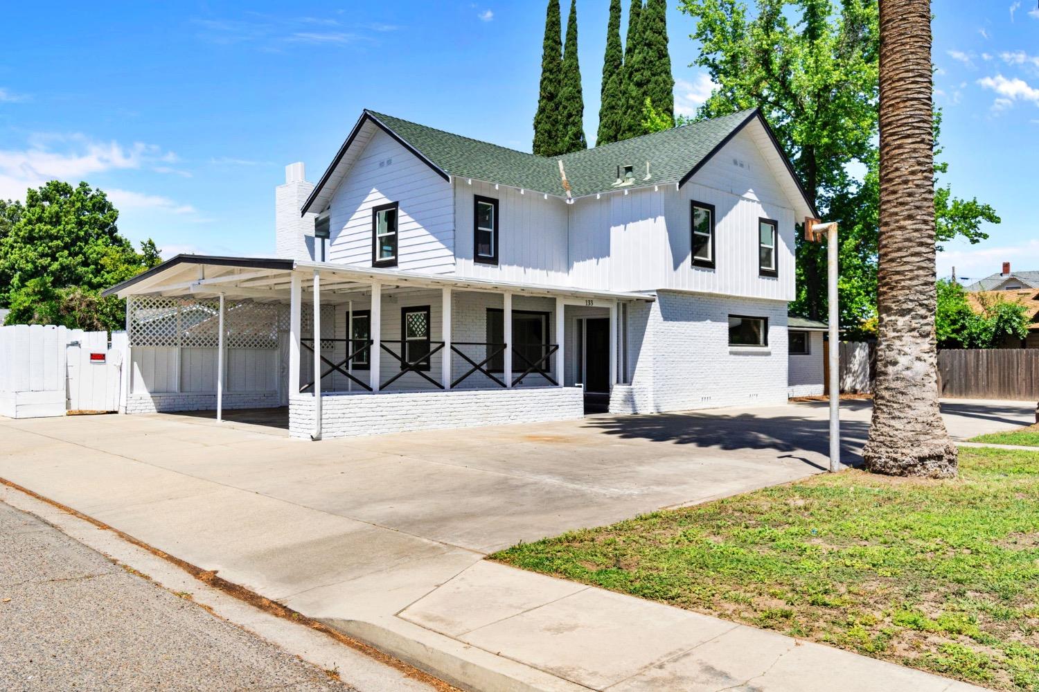 133 South Reed Avenue Reedley, CA 93654 - Photo 3 of 42 a front view of a house with a yard and potted plants
