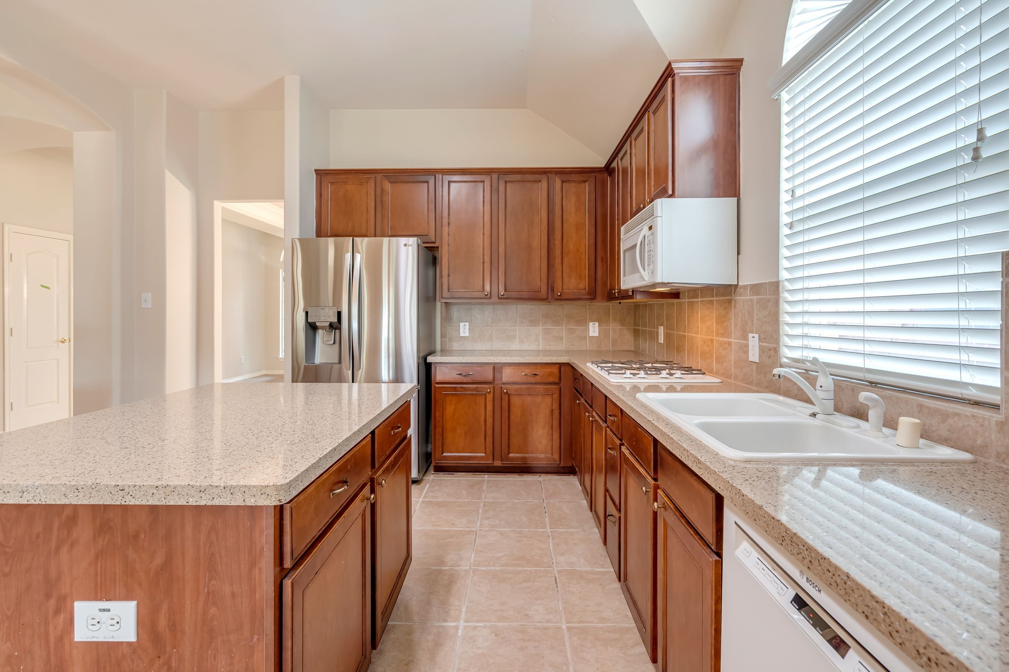 24919 Corbin Gate Drive Spring, TX 77389 - Photo 12 of 29 a kitchen with granite countertop a sink stove and refrigerator