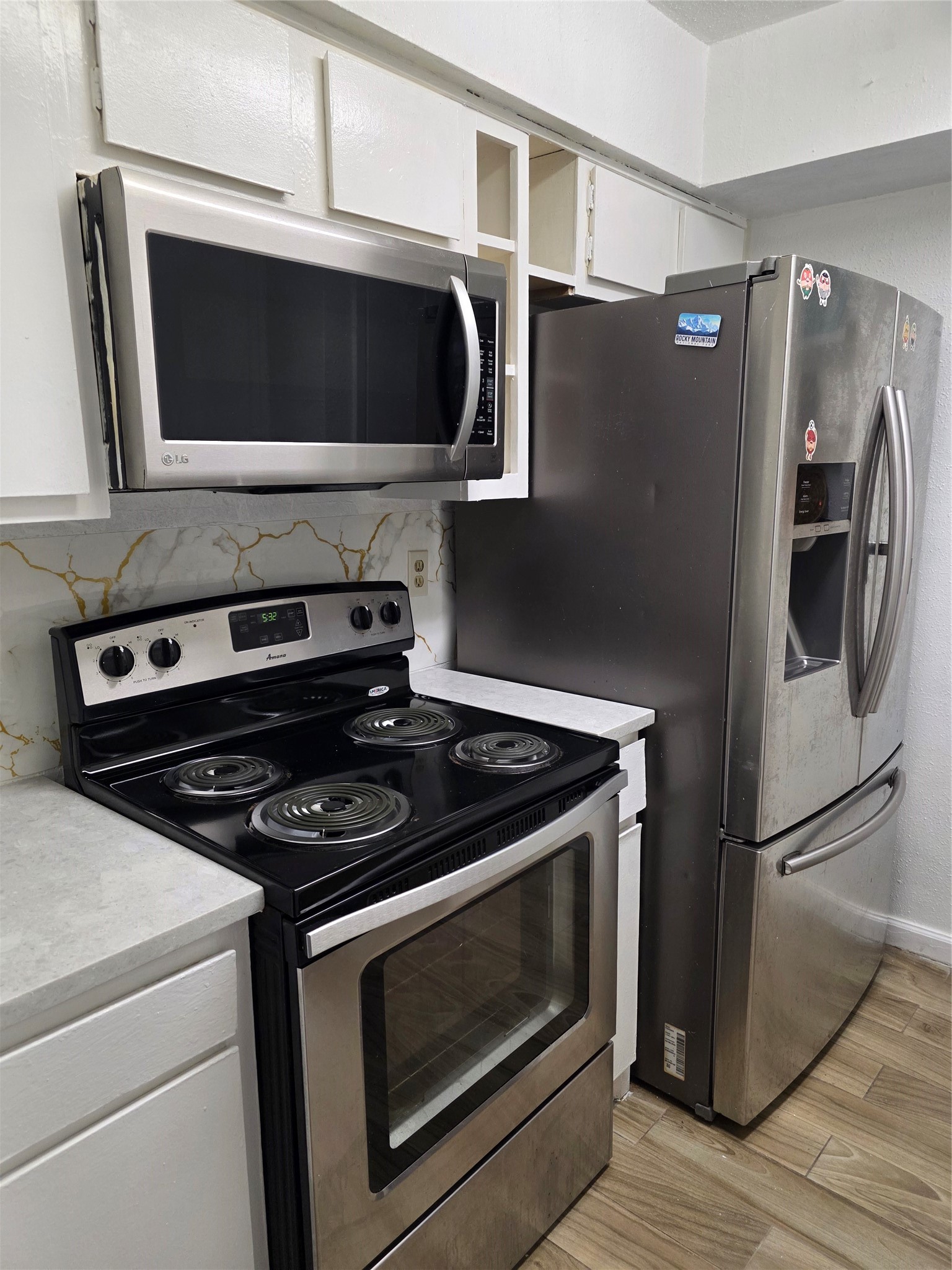 6200 West Tidwell Road, Unit 1702 Houston, TX 77092 - Photo 17 of 24 a kitchen with granite countertop a stove and a microwave with wooden floor