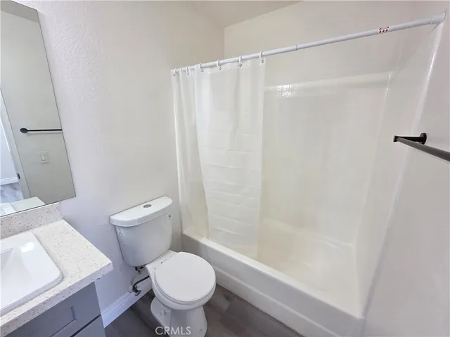a white toilet sitting next to a bath tub