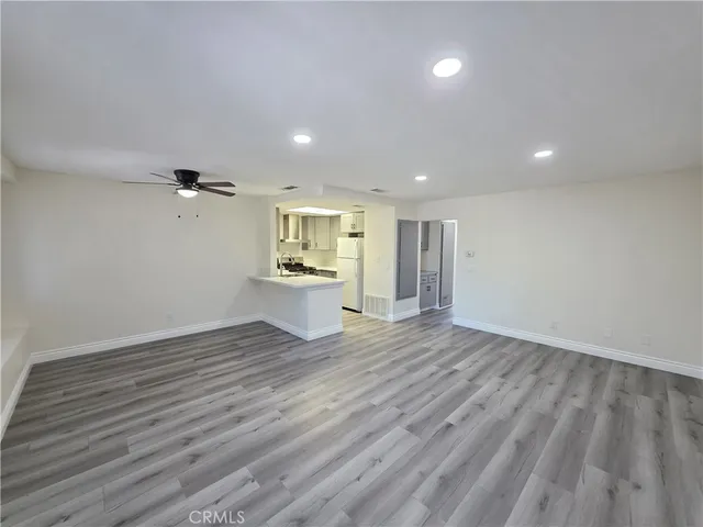 a view of empty room with wooden floor