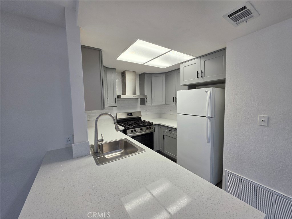 44036 25th Street West, Unit B7 Lancaster, CA 93536 - Photo 4 of 20 a kitchen with a refrigerator and a stove