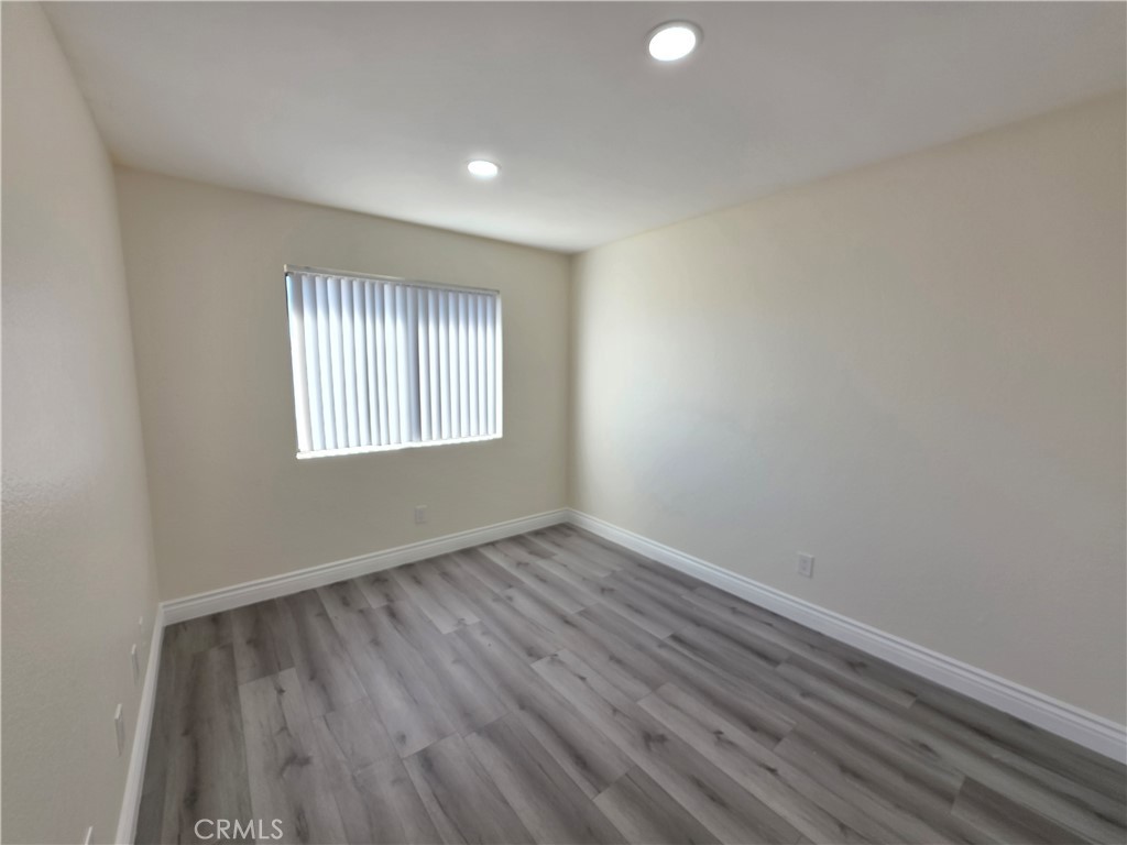 44036 25th Street West, Unit B7 Lancaster, CA 93536 - Photo 5 of 20 an empty room with wooden floor and windows