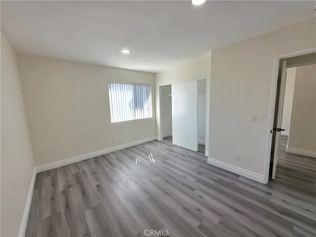 an empty room with wooden floor and a window