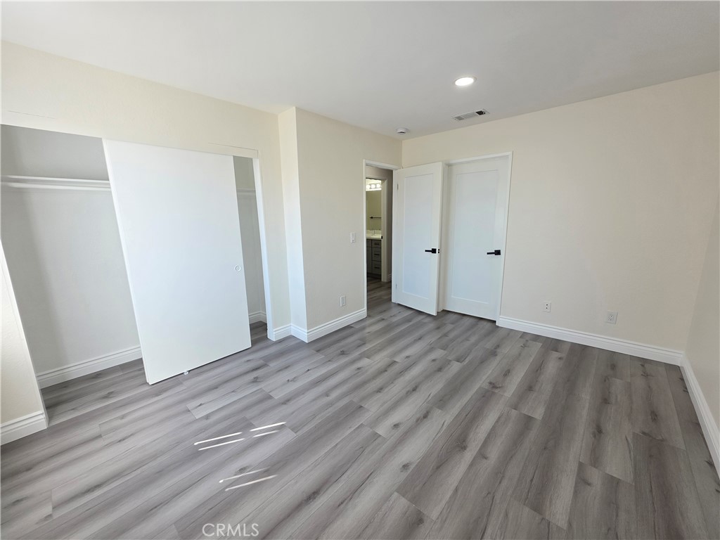 44036 25th Street West, Unit B7 Lancaster, CA 93536 - Photo 10 of 20 a view of wooden floor and windows in a room