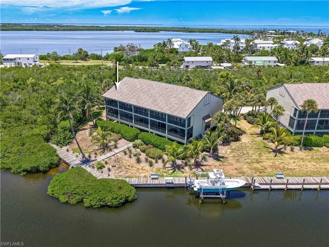 an aerial view of a house with a garden and lake view