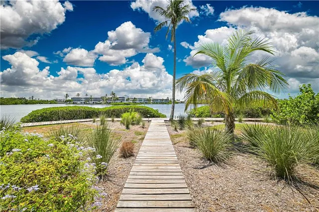 a view of a lake with a floor to ceiling window and potted plants