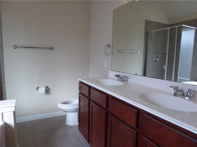 a bathroom with a double vanity sink toilet and a mirror