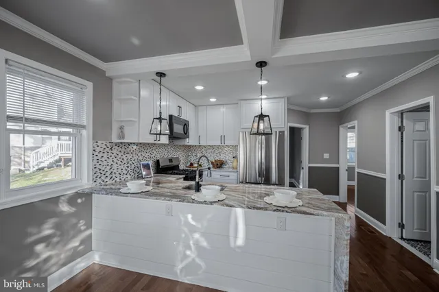 a kitchen with stainless steel appliances granite countertop a sink refrigerator and cabinets
