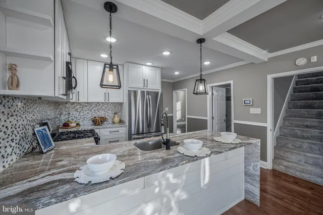 a kitchen with granite countertop a sink and a refrigerator