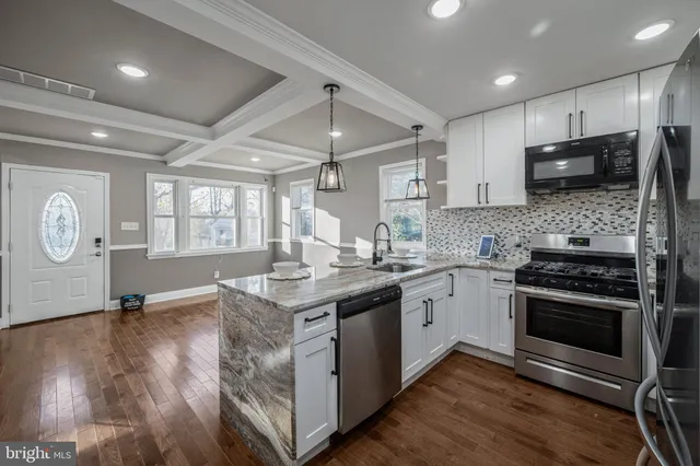 a kitchen with stainless steel appliances granite countertop a stove a sink and a microwave